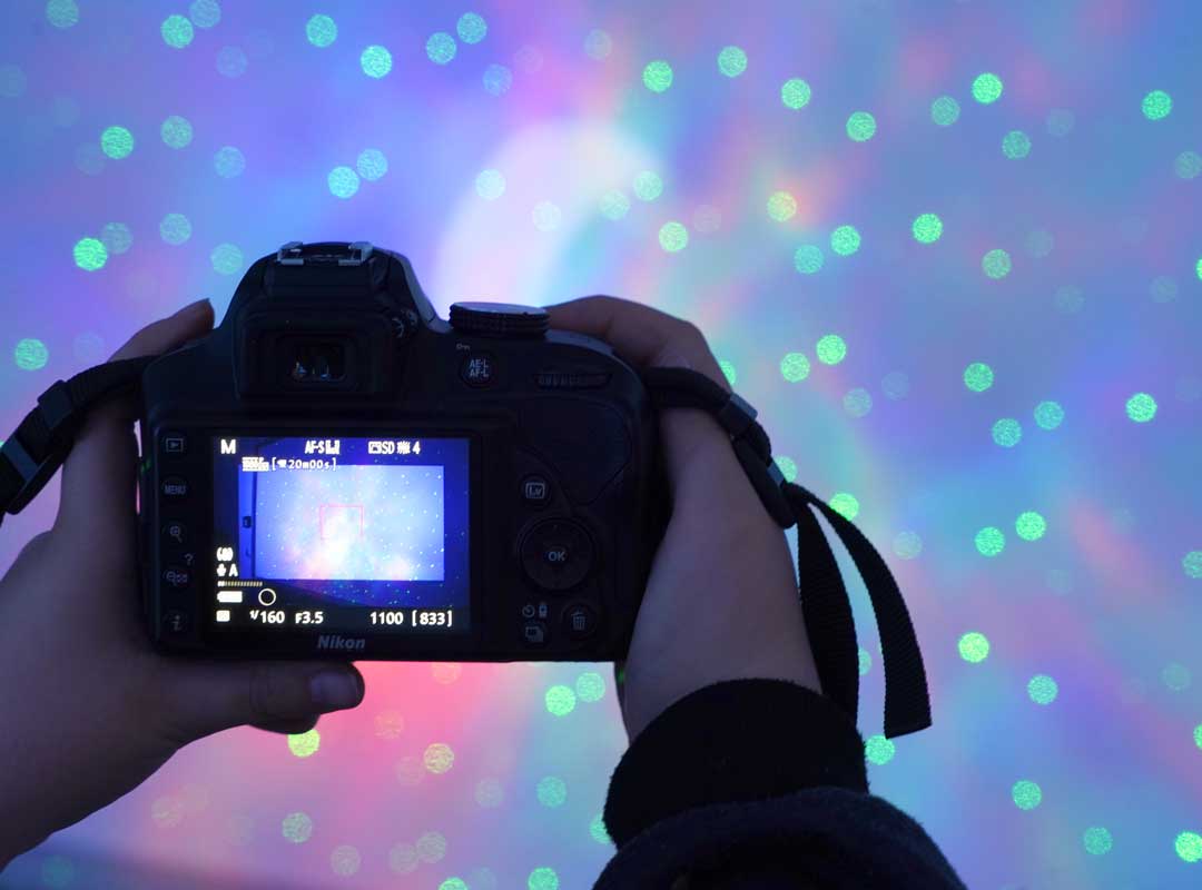 Kamera in Kinderhand vor einem Sternenhimmel