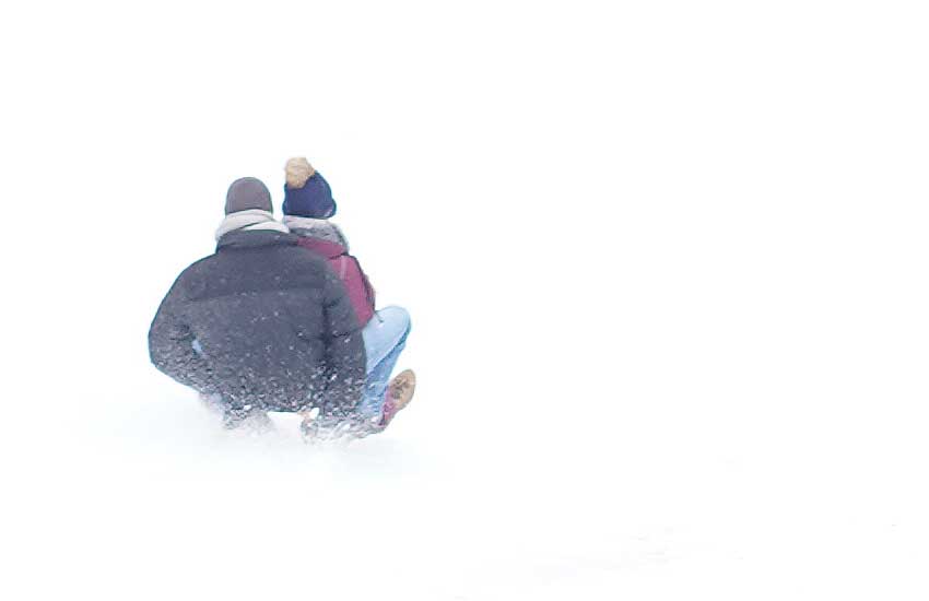 Schlittenfahrt auf dem weißen Skihang. Ideales Wintermotiv.